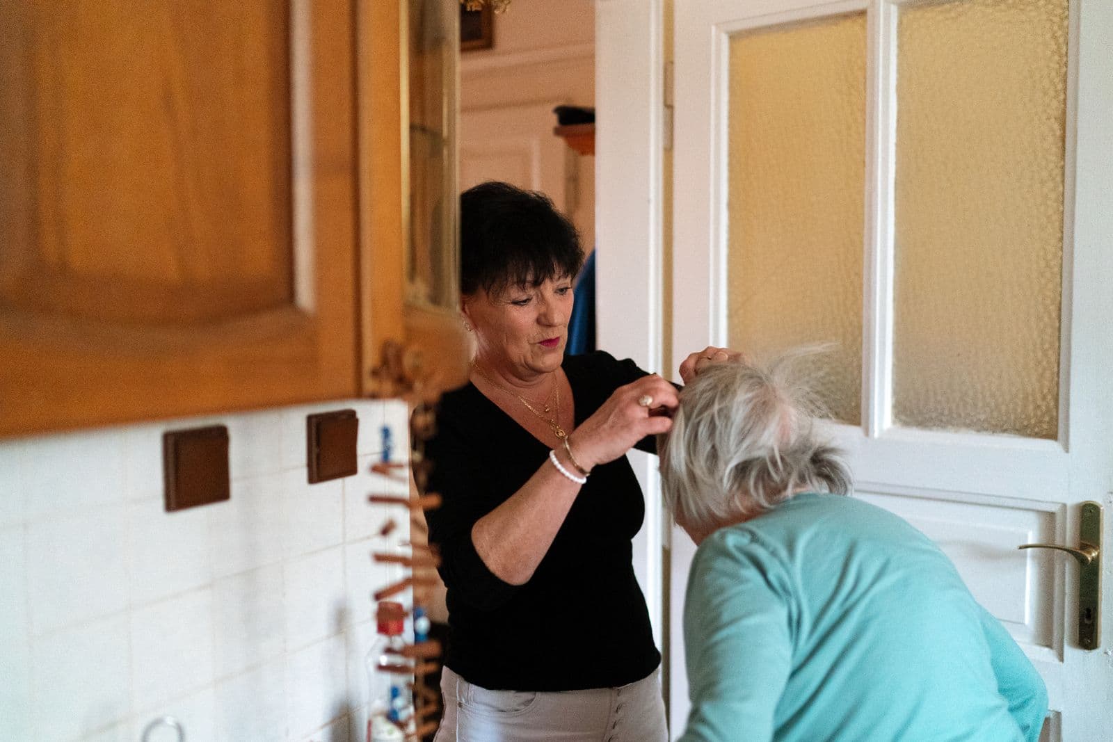 A caregiver gently helping an older adult with a personal care routine at home